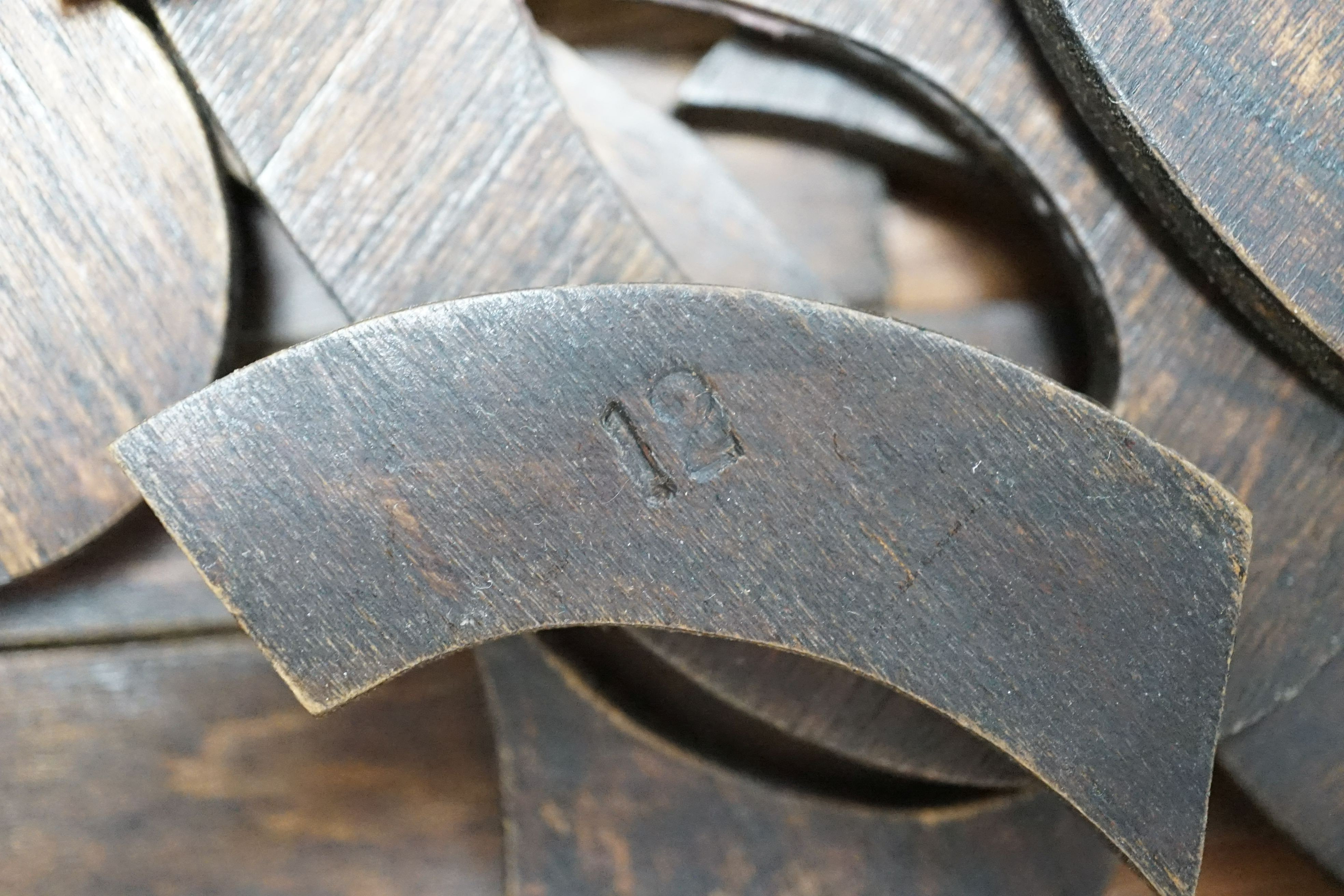 A quantity of cut wood shapes, letters and quotation marks, possibly a puzzle, in wooden box